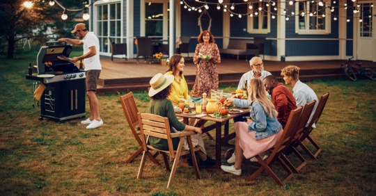 Family and Friends Having an Open Air Barbecue Dinner in Their Backyard
